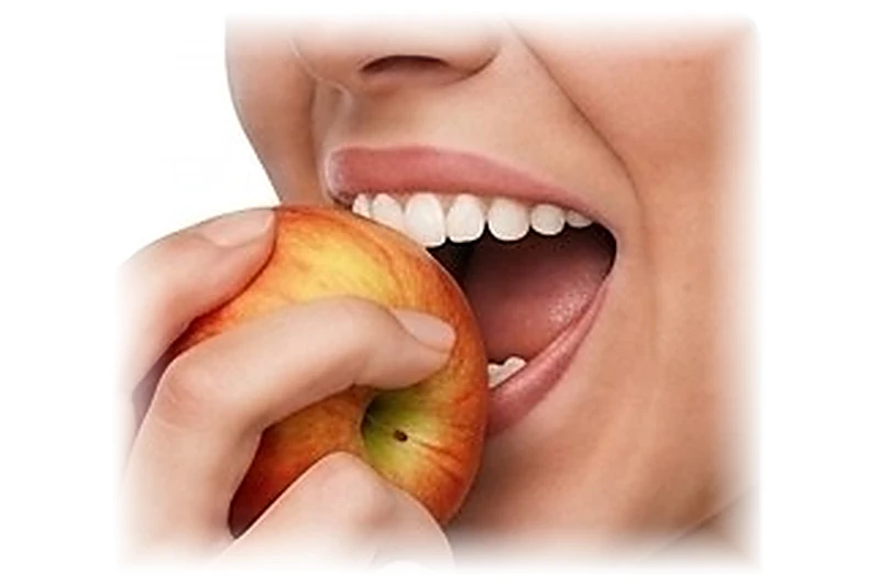 Primer plano de una persona mordiendo una manzana.